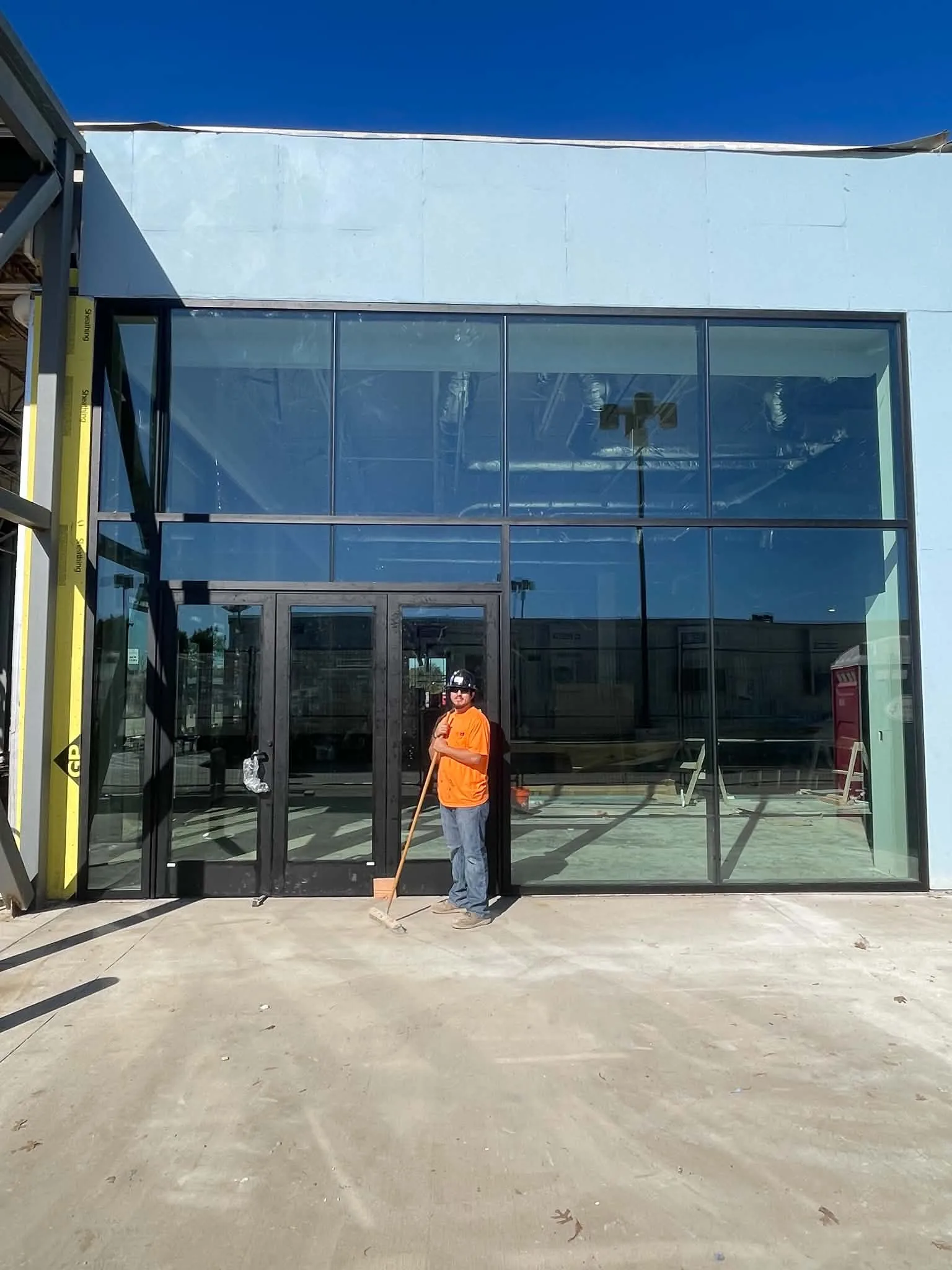 Glazier in front of a newly installed storefront entrance